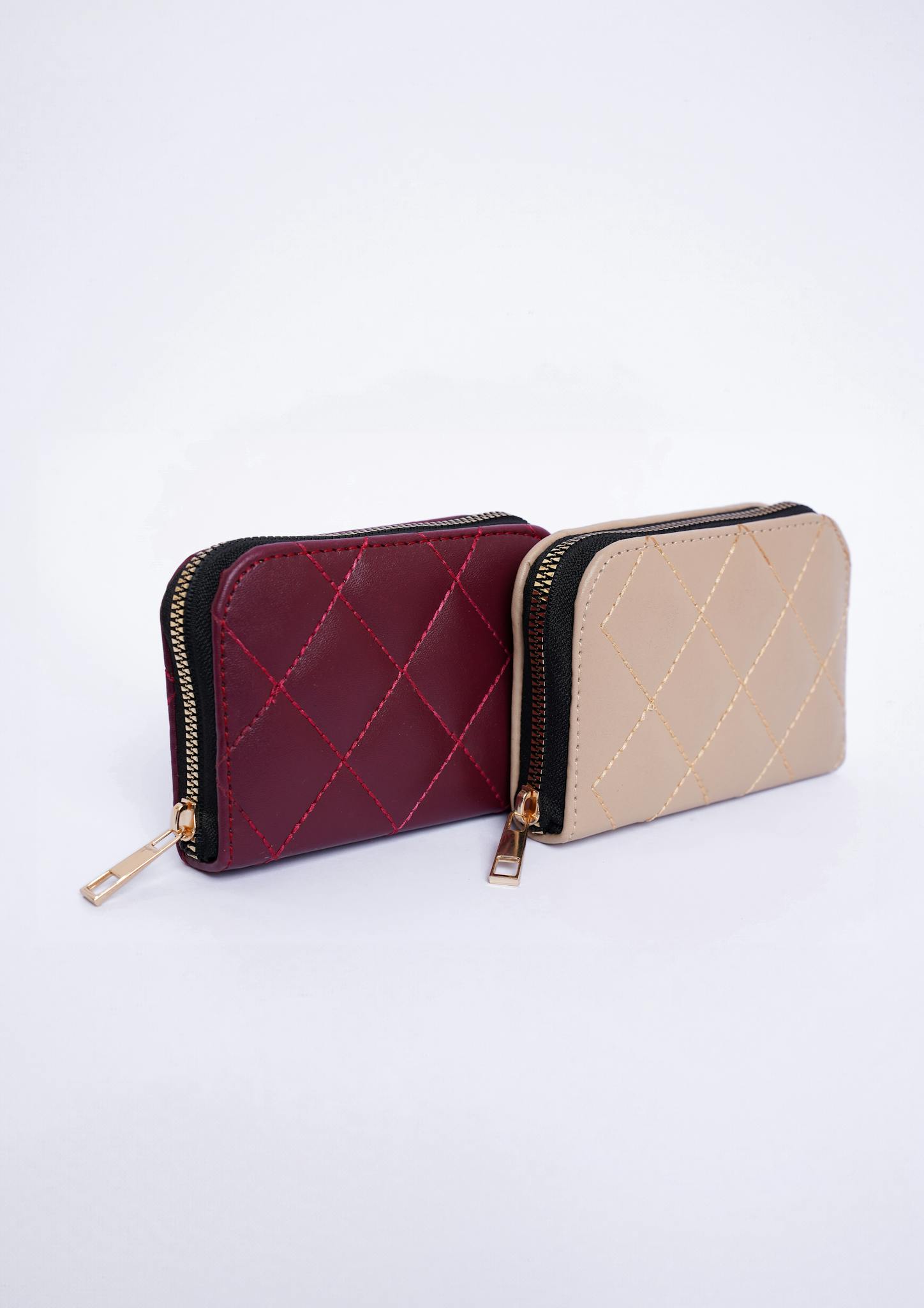Stylish red and beige leather wallets displayed in a studio setting, perfect for fashion advertising.